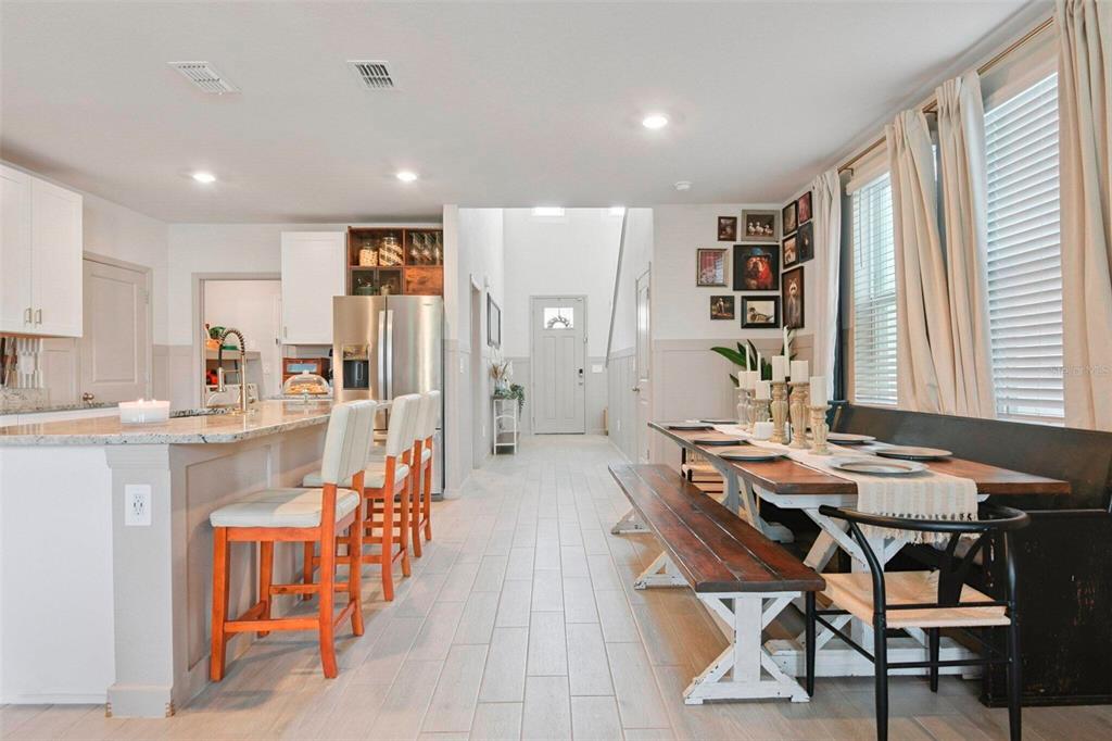 A kitchen with a breakfast bar and an adjacent dining area featuring a wooden table — 3610 RADIANT MOUNTAIN DRIVE, PLANT CITY, FL