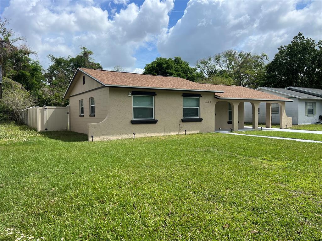 A single-story tan house with a brown shingled roof and a front porch — 1069 PRINCEWOOD, ORLANDO, FL