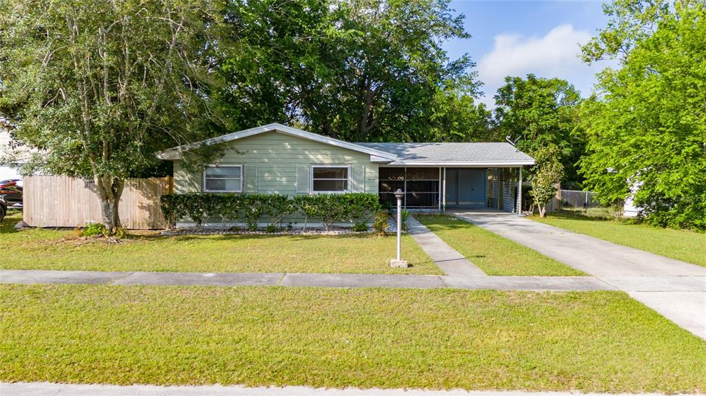 A single-story house with light green siding, a carport, and a front lawn — 14644 SW 35TH TERRACE ROAD, OCALA, FL