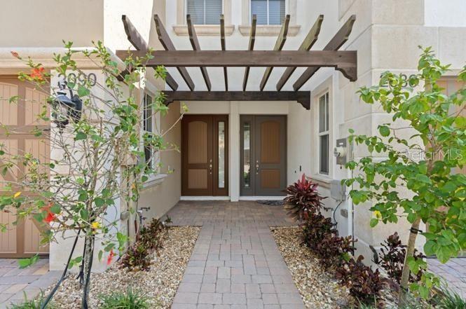 The exterior view shows two front doors under a wooden pergola with a paved walkway — 2086 FOXTAIL VIEW COURT, WEST PALM BEACH, FL