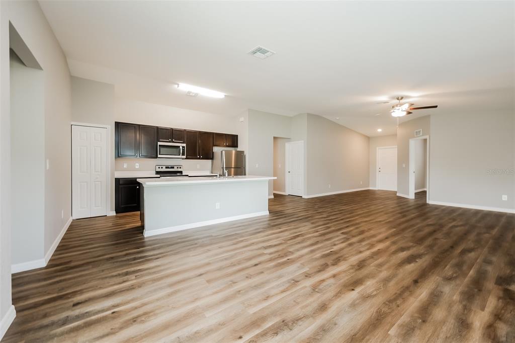 An open-concept kitchen with dark cabinets and a breakfast bar overlooks a spacious living area — 3637 STARBOARD AVENUE, NORTH PORT, FL