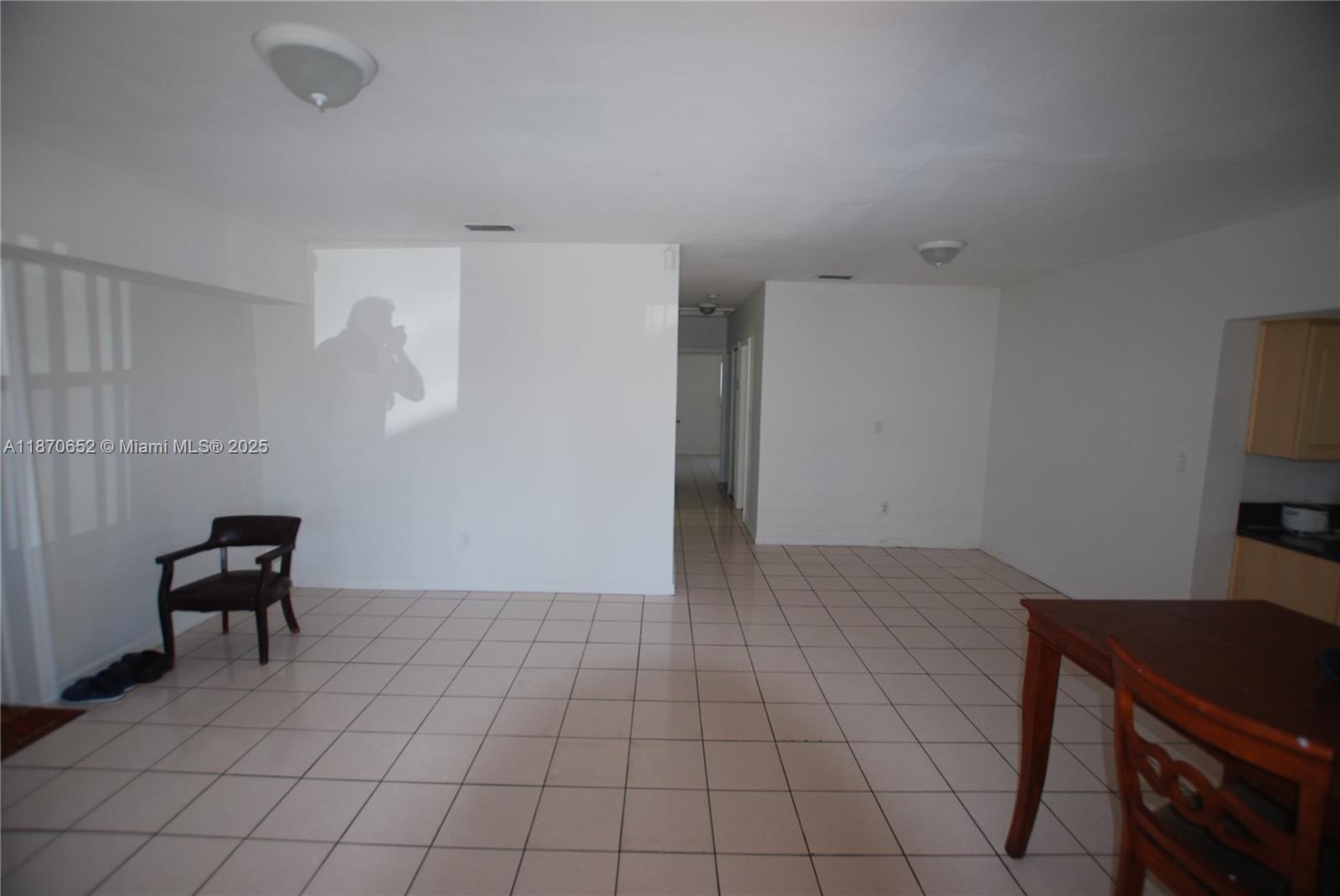 An open-concept room features white walls, light-colored tile flooring, and a small dining area — 1801 NE 176th St, North Miami Beach FL 33162, NORTH MIAMI BEACH, FL