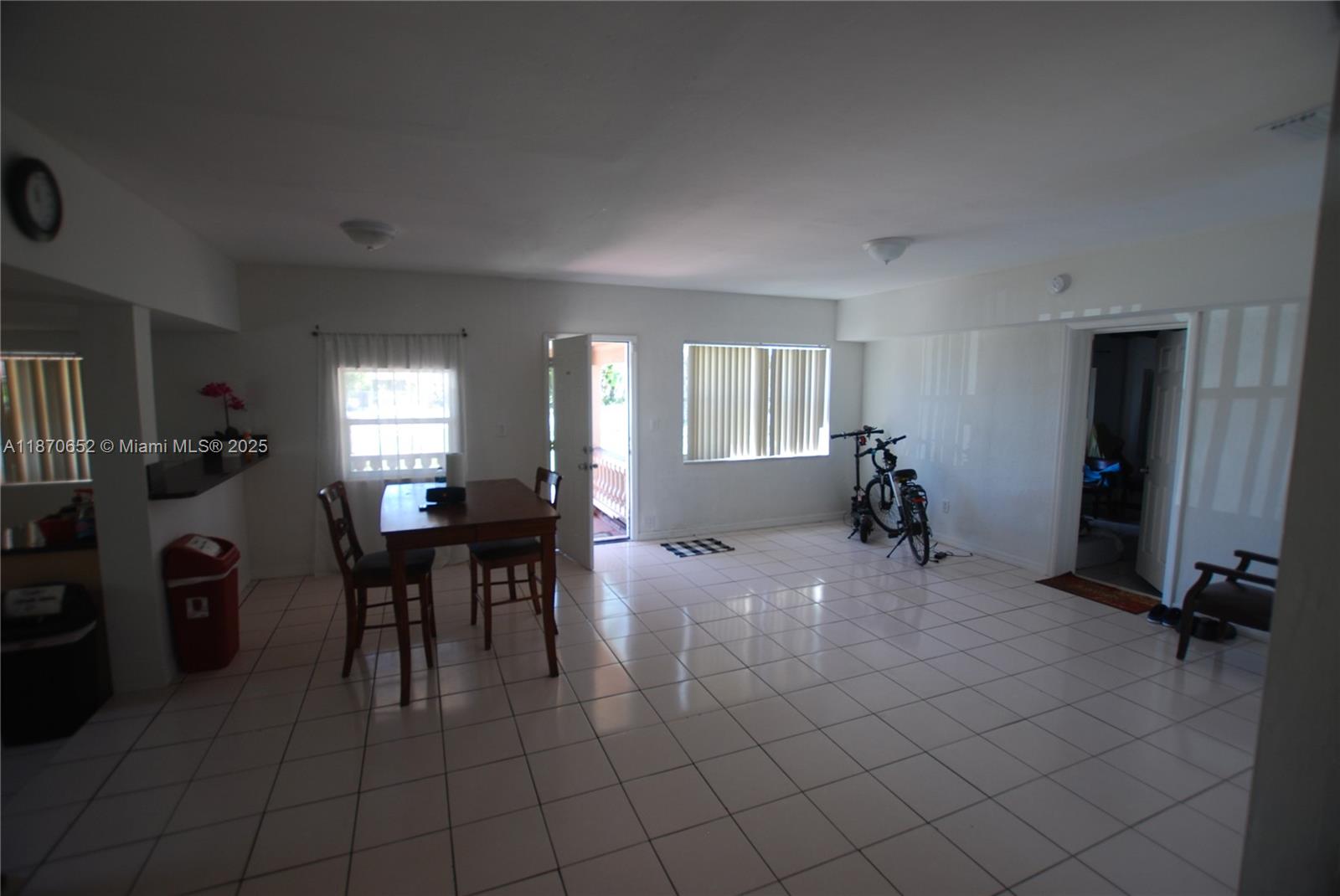 This room features white tile flooring, a dining table, and an open doorway to outside — 1801 NE 176th St, North Miami Beach FL 33162, NORTH MIAMI BEACH, FL