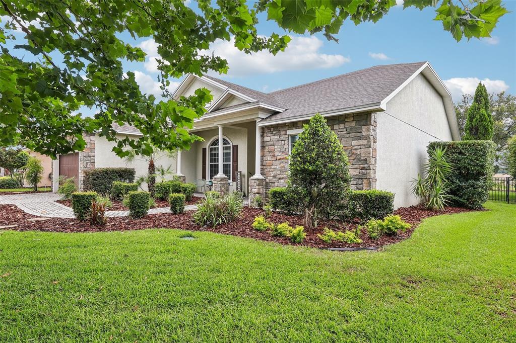A single-story house with stone veneer, stucco siding, and a paved driveway — 4322 TOKOSE PLACE, LAKELAND, FL