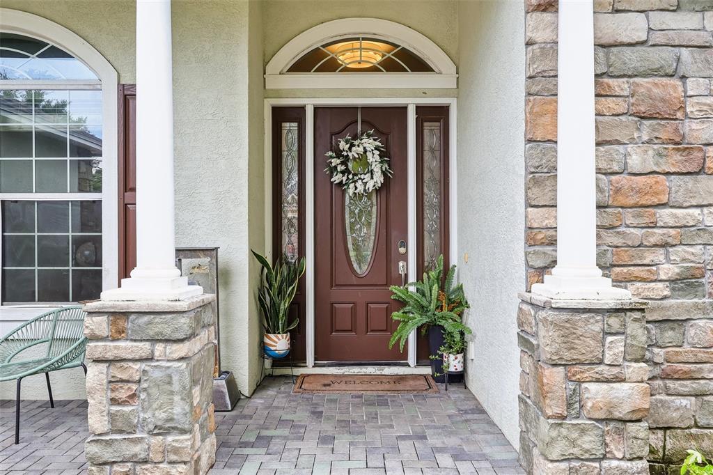 The front entrance features a brown door with glass panels, a wreath, and stone columns — 4322 TOKOSE PLACE, LAKELAND, FL