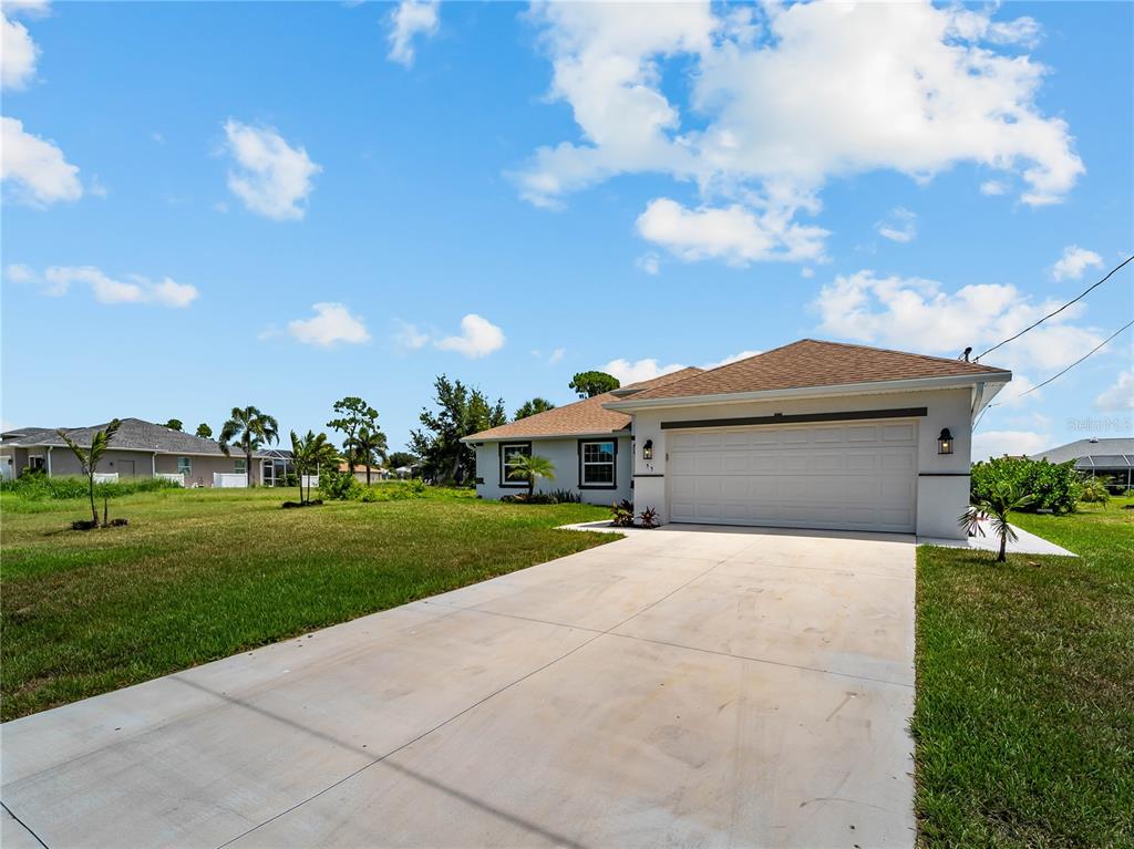 A single-story house with a white exterior, a two-car garage, and a concrete driveway — 55 PINE VALLEY LANE, ROTONDA WEST, FL