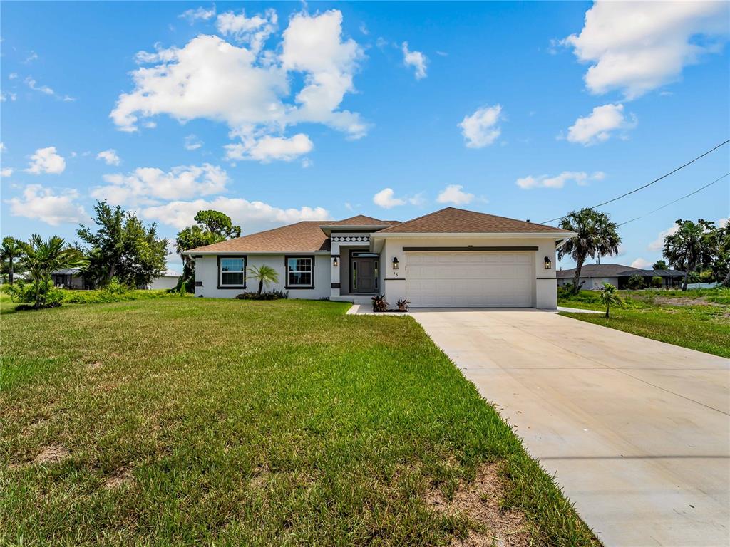 A single-story house with a white exterior, a brown roof, and a concrete driveway — 55 PINE VALLEY LANE, ROTONDA WEST, FL