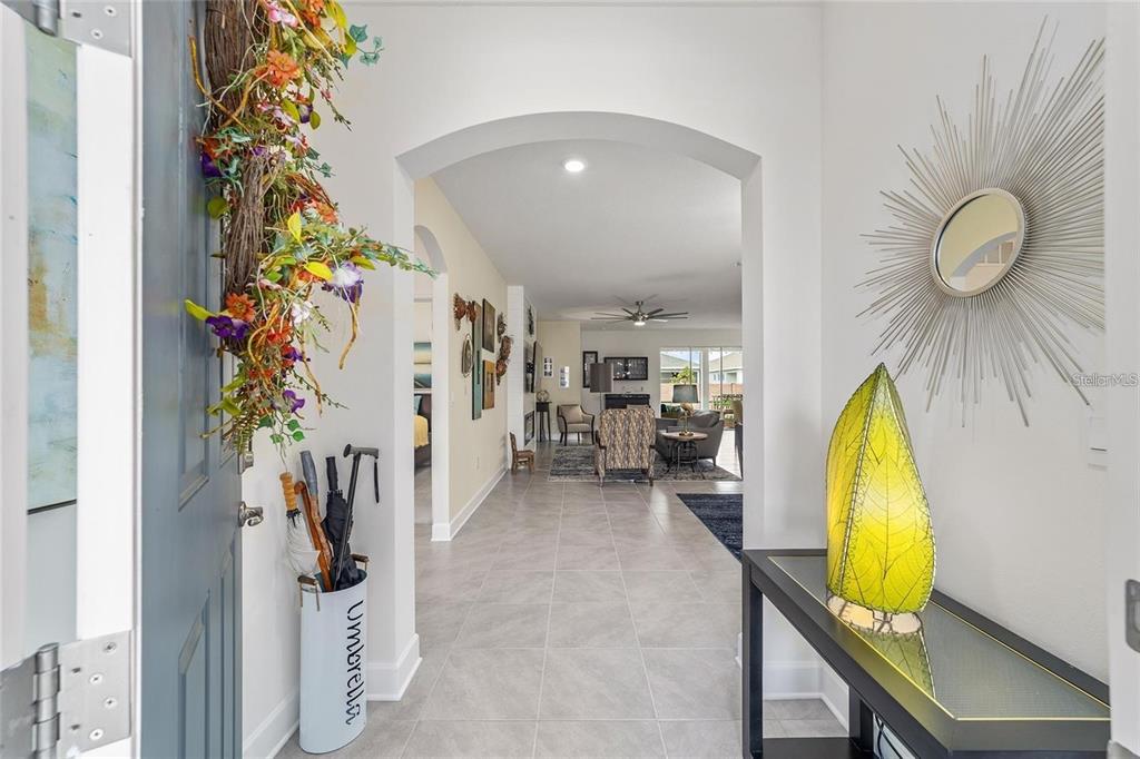 An entryway with a tile floor leads through an arched doorway into a living room — 4395 NW 55TH TERRACE, OCALA, FL