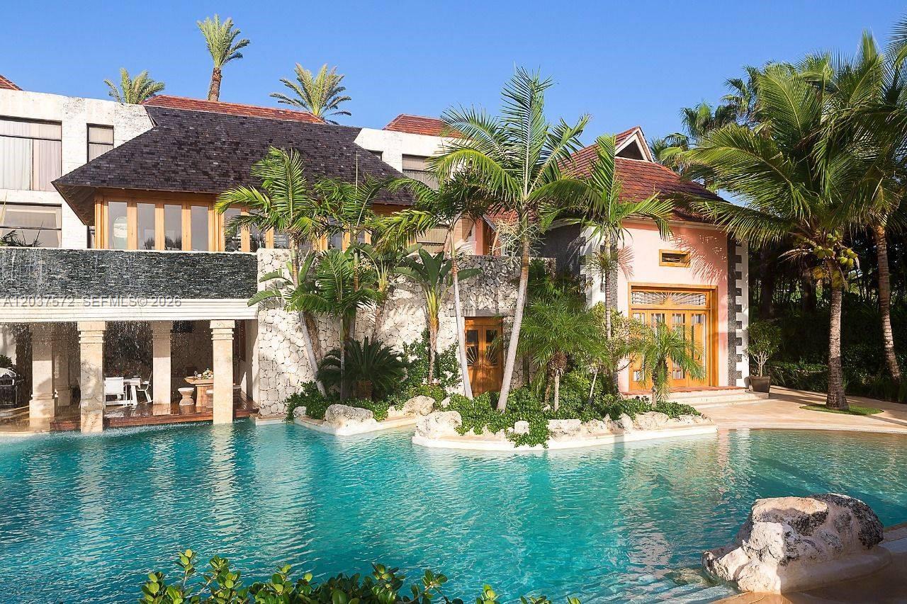 A multi-story house with a stone facade and a swimming pool in the foreground — 0 Cana cap, FL, FL