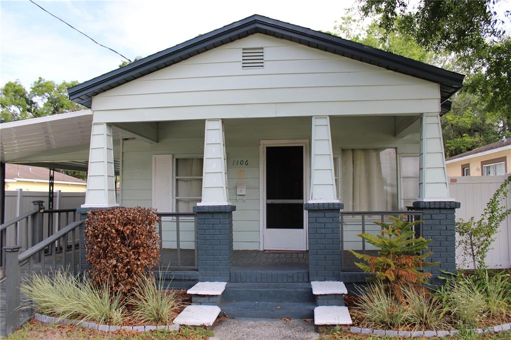 A light green single-story house features a front porch with dark brick columns and stairs — 1106 E DR MARTIN LUTHER KING JR BOULEVARD, PLANT CITY, FL