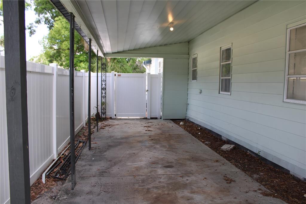 A light green house with a covered front porch, dark railings, and brick-based columns — 1106 E DR MARTIN LUTHER KING JR BOULEVARD, PLANT CITY, FL