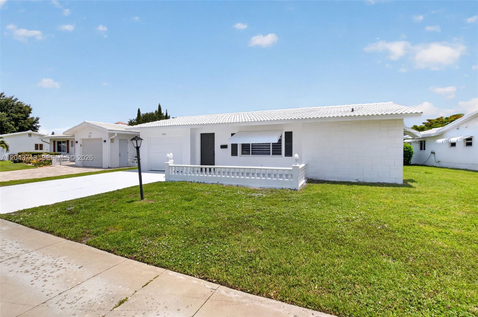 A white single-story house with a tiled roof, a front lawn, and a concrete driveway — 1502 SW 17th Ave, Boynton Beach FL 33426, BOYNTON BEACH, FL