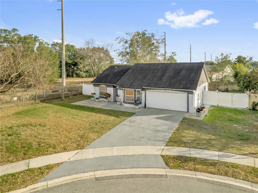 An aerial view shows a single-story house with a gray exterior, dark roof, and driveway — 7702 LEGACY LANE, ORLANDO, FL