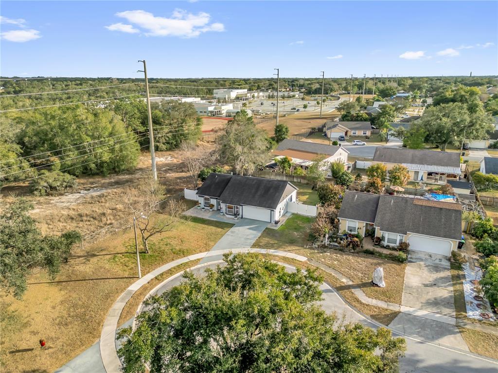 An aerial view shows a suburban cul-de-sac with two houses and a large grassy lot — 7702 LEGACY LANE, ORLANDO, FL