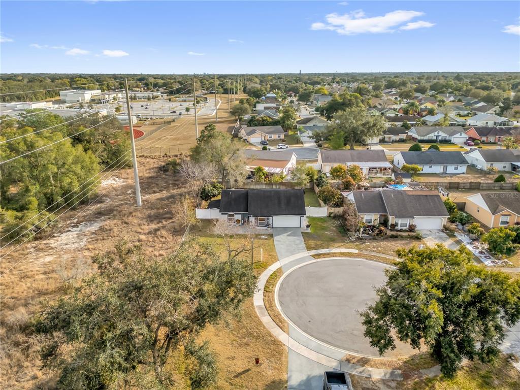 An aerial view shows a suburban house with a driveway facing a cul-de-sac — 7702 LEGACY LANE, ORLANDO, FL