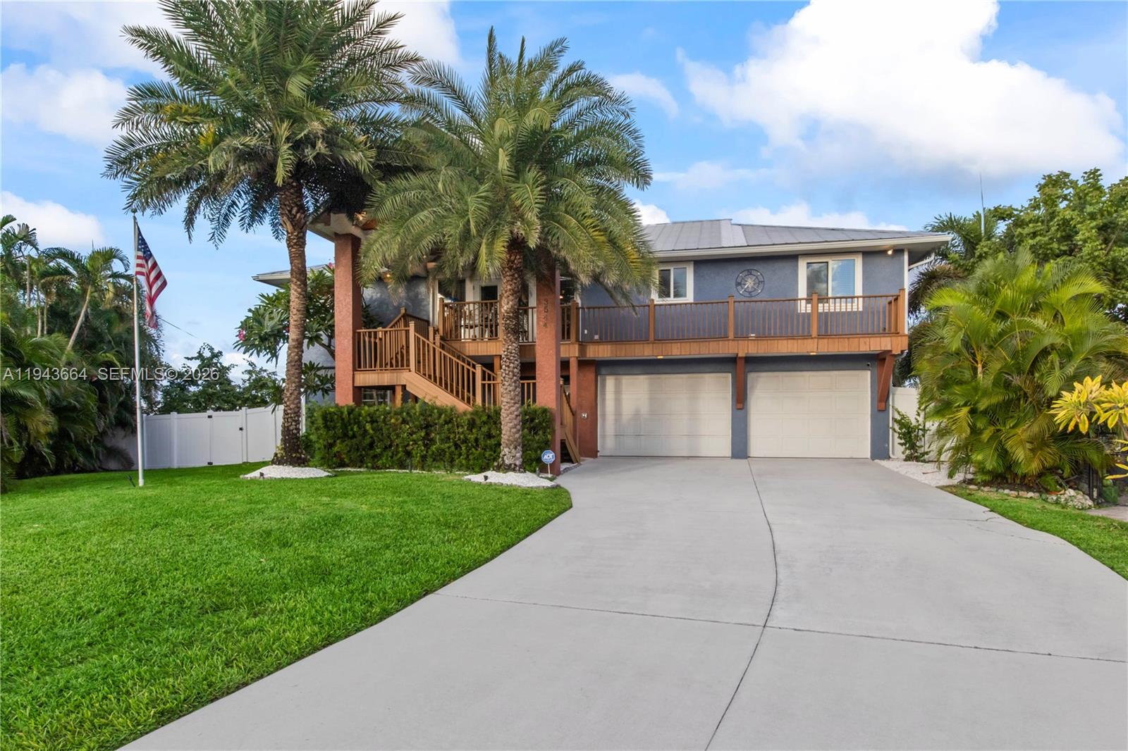 A two-story house with a two-car garage, wooden deck, and palm trees in the front yard — OTHER CITY - IN THE STATE OF FLORIDA, FL