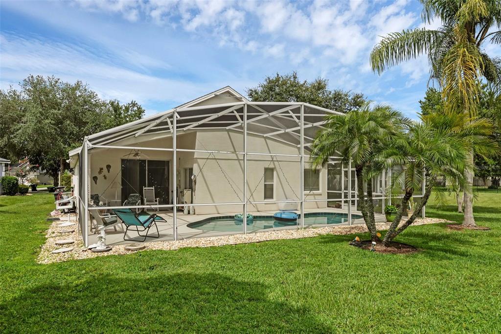 A backyard view of a house with a screened-in pool and patio area — 4919 JETTON DRIVE, ORLANDO, FL