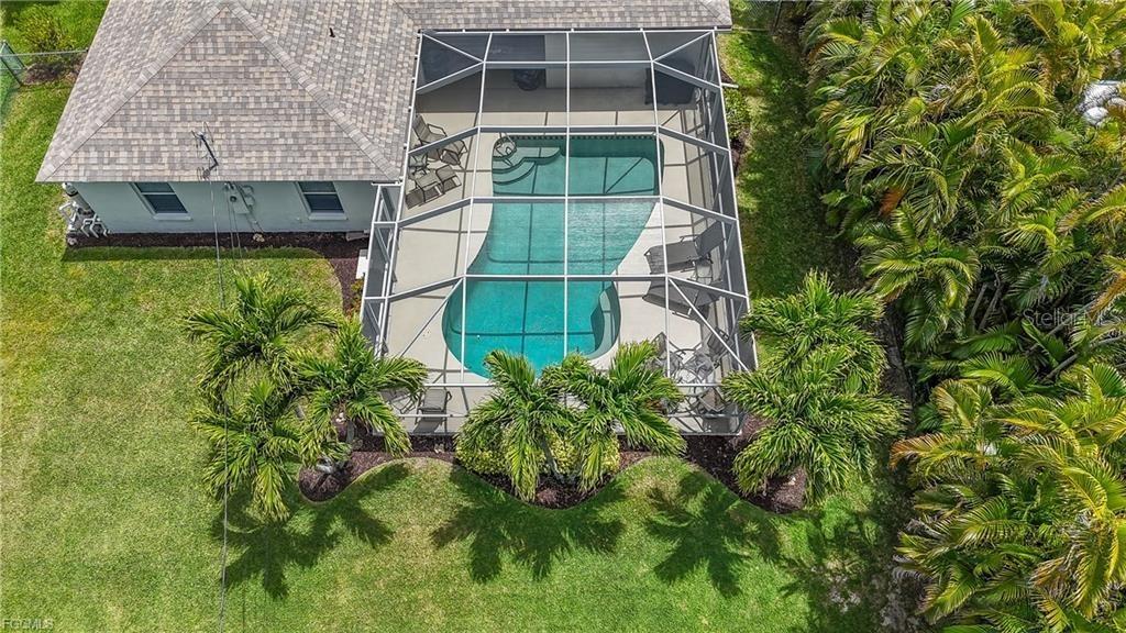 An aerial view shows a house with a screened-in pool and surrounding palm trees — 4522 SW 1ST AVENUE, CAPE CORAL, FL
