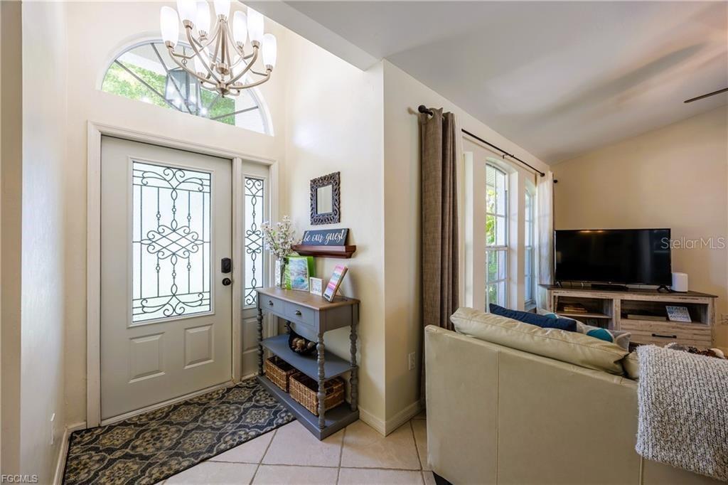 An entryway with a decorative front door, tile flooring, and a console table — 4522 SW 1ST AVENUE, CAPE CORAL, FL