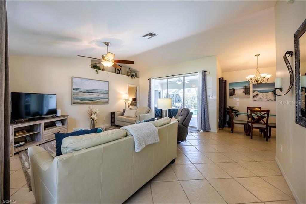 A living room with tile floors, a ceiling fan, and a sliding glass door — 4522 SW 1ST AVENUE, CAPE CORAL, FL