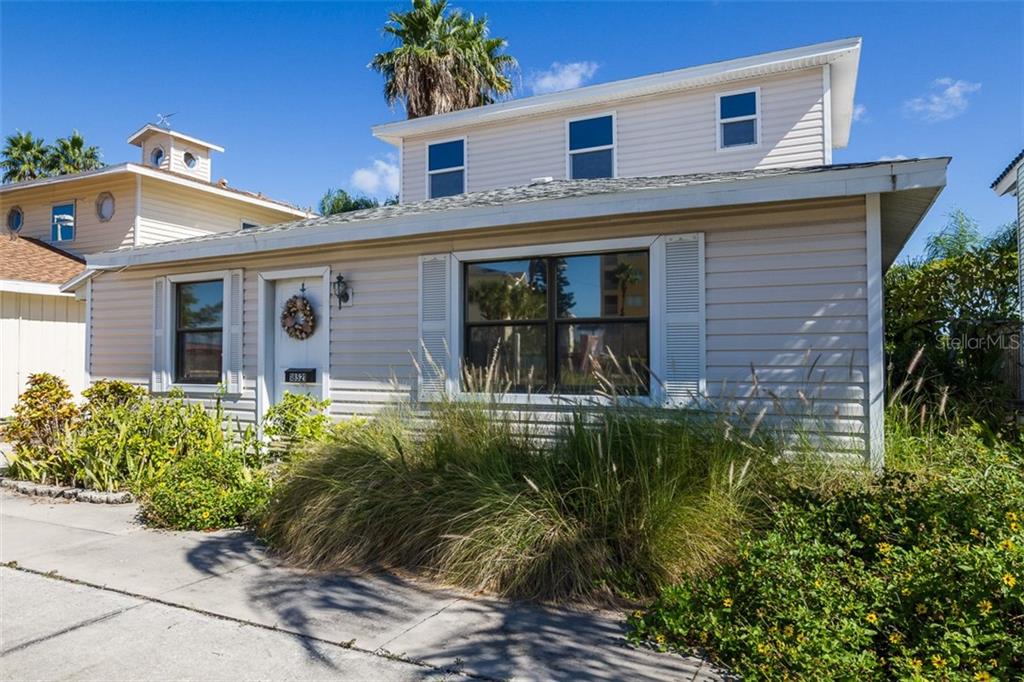 A two-story house with light-colored horizontal siding and a front yard with tall grasses — 18521 GULF BOULEVARD, INDIAN SHORES, FL