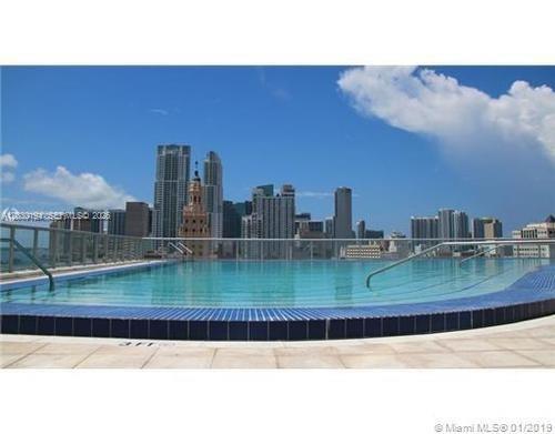A rooftop swimming pool overlooks the Miami skyline under a clear blue sky — 888 Biscayne Blvd # 2911, Miami FL 33132, MIAMI, FL