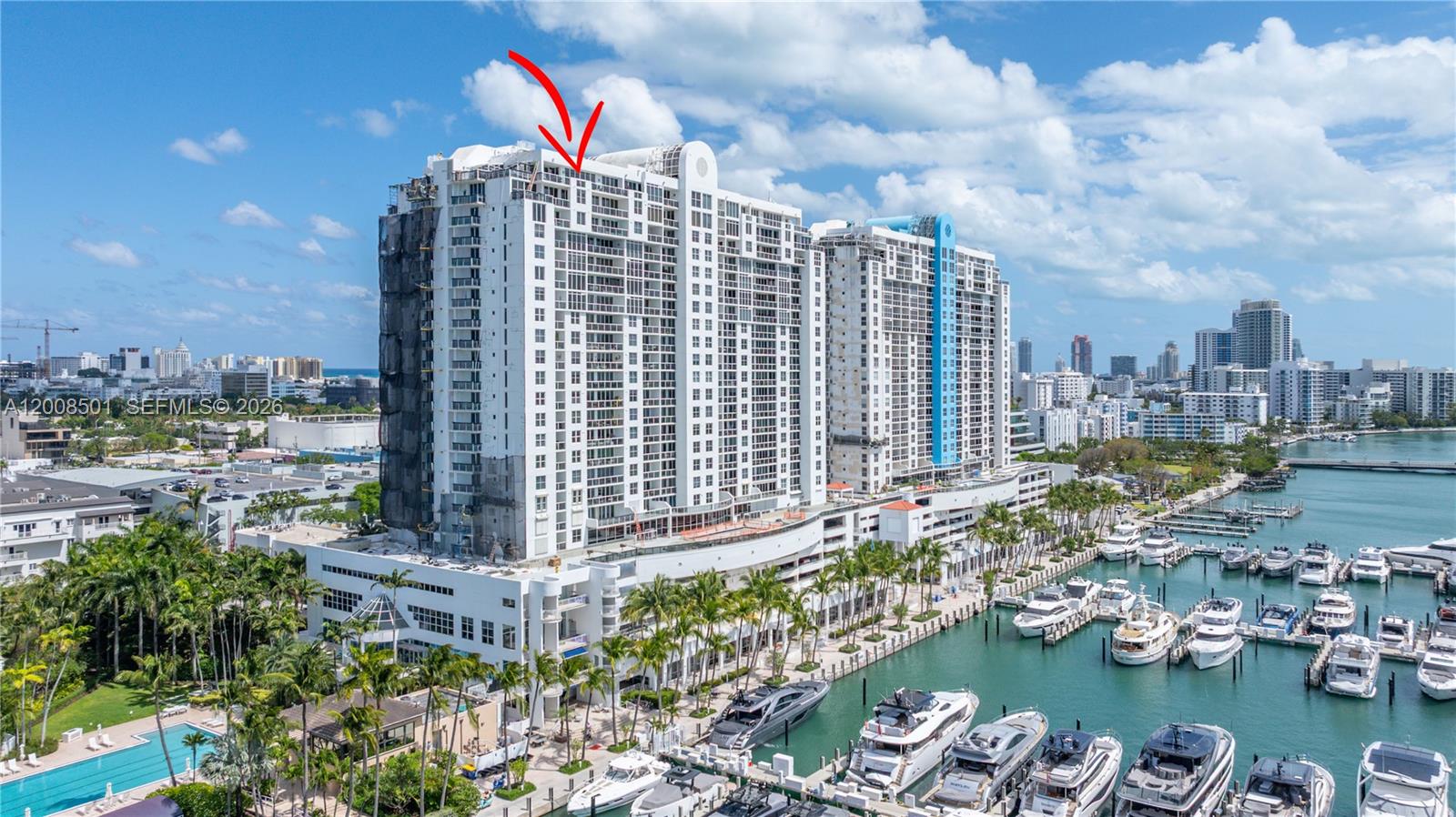 An aerial view shows a large waterfront residential building with a marina and yachts — 1900 Sunset Harbour Dr, Miami Beach FL 33139, MIAMI BEACH, FL