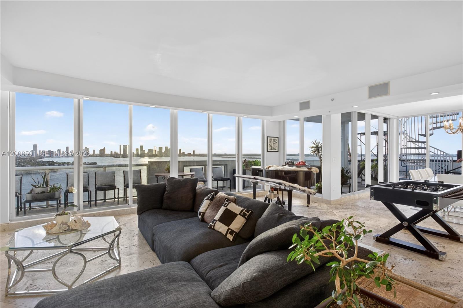 A living room features a large sectional sofa, a foosball table, and floor-to-ceiling windows — 1900 Sunset Harbour Dr, Miami Beach FL 33139, MIAMI BEACH, FL