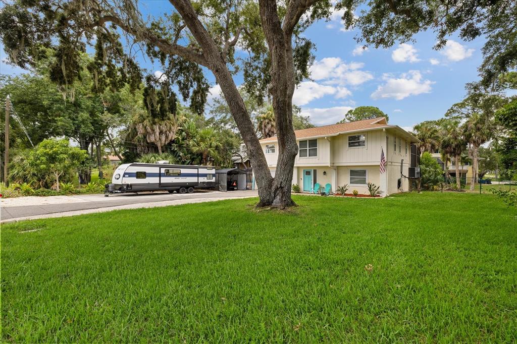 A two-story yellow house with a camper parked on the side of the lawn — 1410 RIVERSIDE DRIVE, TARPON SPRINGS, FL