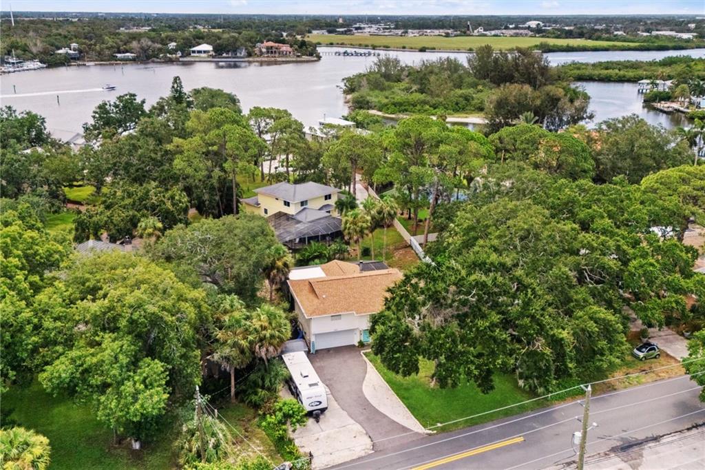 An aerial view shows a house with a tan roof, a driveway, and a camper — 1410 RIVERSIDE DRIVE, TARPON SPRINGS, FL