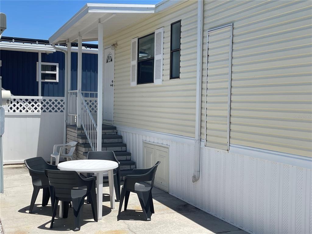 A mobile home exterior features a concrete patio with a table and chairs — 3710 GULF OF MEXICO DRIVE UNIT G20, LONGBOAT KEY, FL