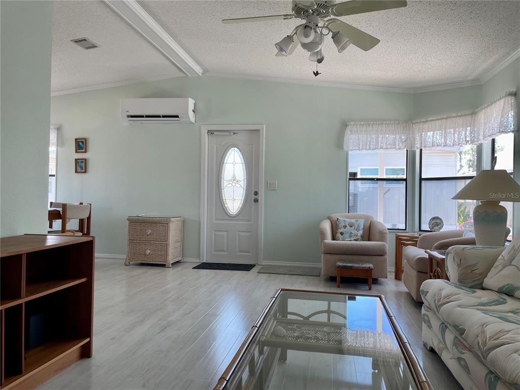 A living room features light-colored wood flooring, a ceiling fan, and a white front door — 3710 GULF OF MEXICO DRIVE UNIT G20, LONGBOAT KEY, FL