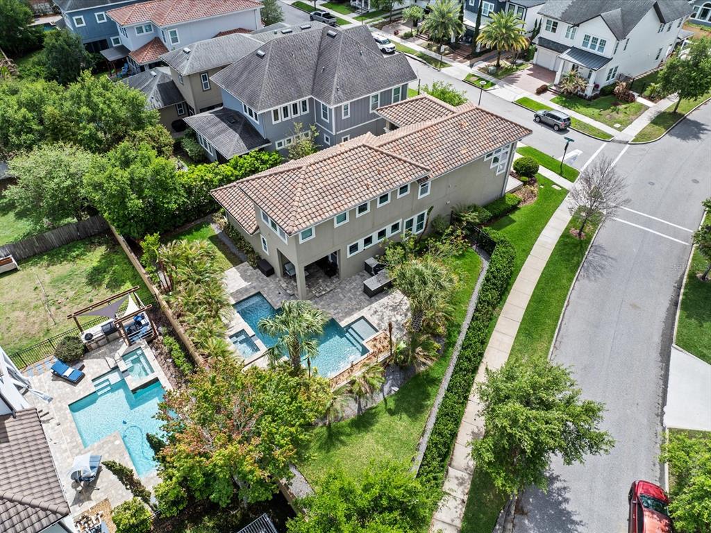An aerial view shows a two-story house with a backyard pool and patio area — 8153 BELLOW STREET, ORLANDO, FL
