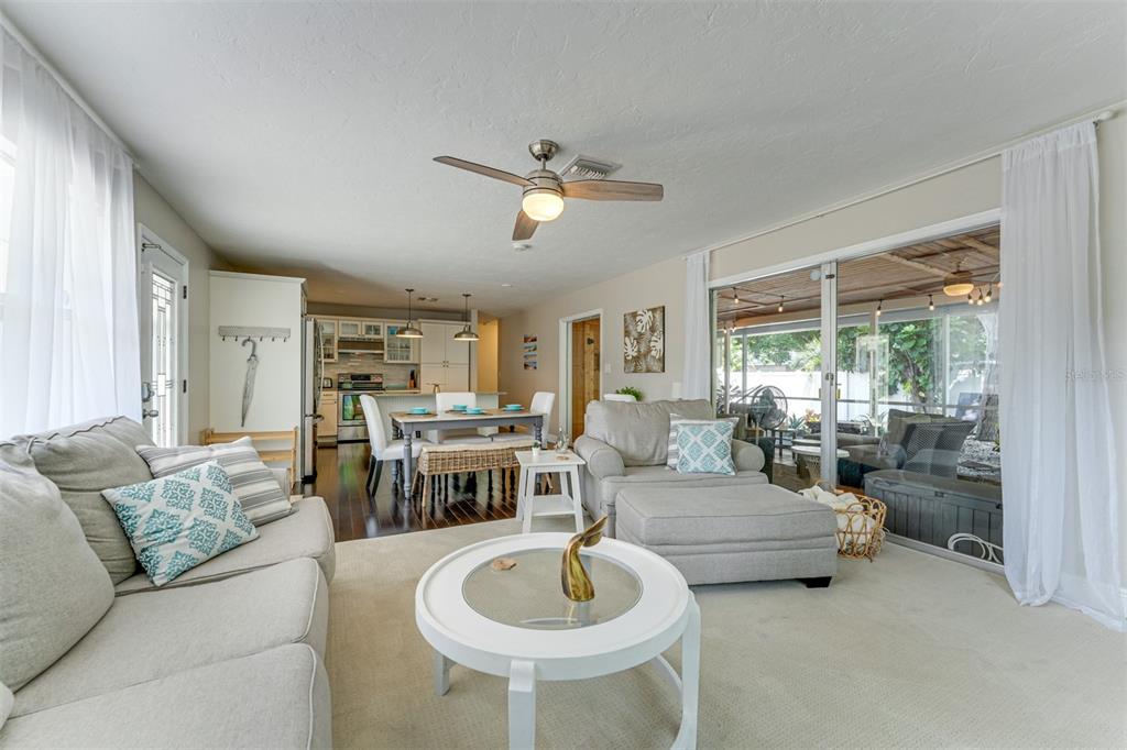 A living room with a sofa, armchair, and coffee table opens to a dining area — 2363 MILFORD CIRCLE, SARASOTA, FL
