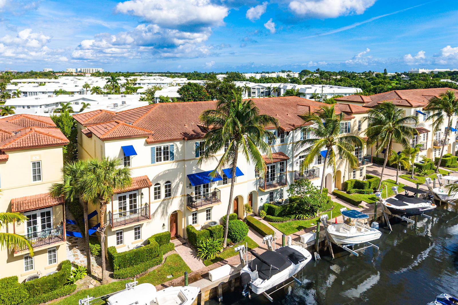 An aerial view of multi-story townhomes with tile roofs, balconies, and private boat slips — 824 Virginia Garden Drive, Boynton Beach FL 33435, BOYNTON BEACH, FL