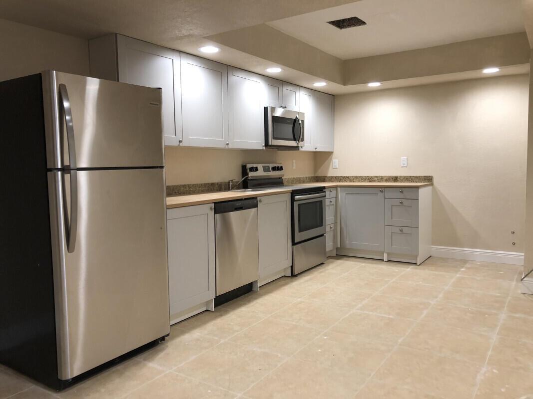A kitchen with light gray cabinets, stainless steel appliances, and light-colored tile flooring — 279 SE 8th Terrace # A, Deerfield Beach FL 33441, DEERFIELD BEACH, FL