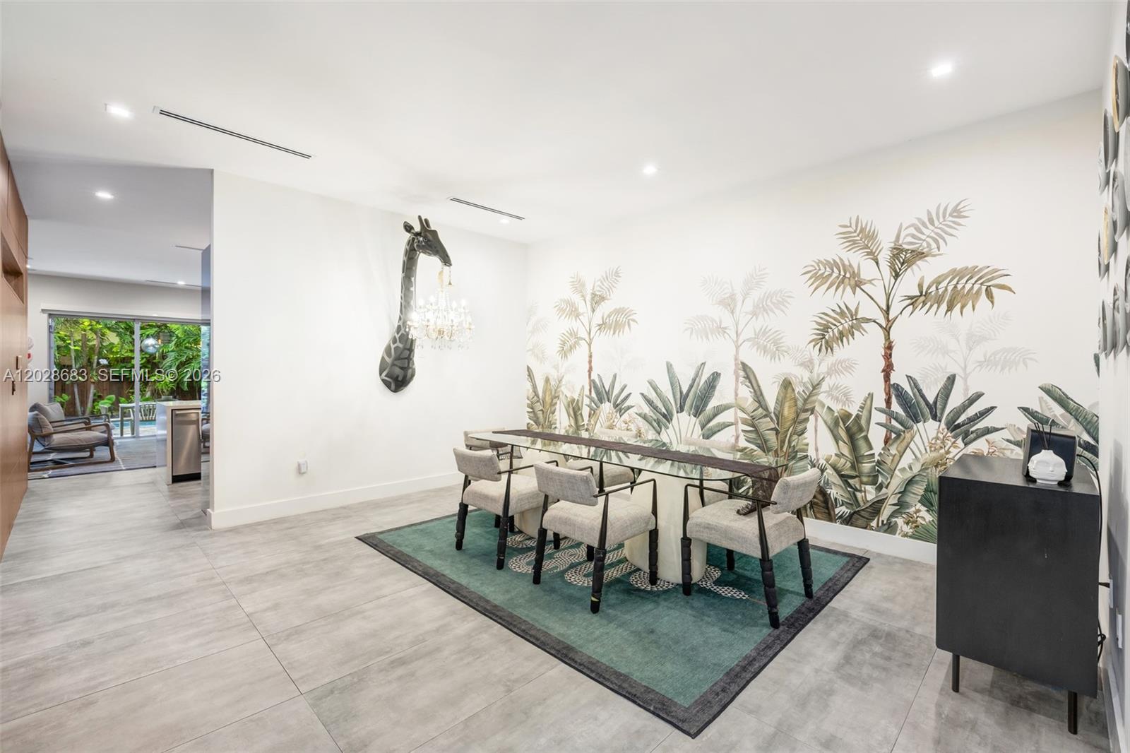 A dining room features a glass table, giraffe wall sculpture, and tropical wallpaper — 3135 Ohio St # 3135, Miami FL 33133, MIAMI, FL