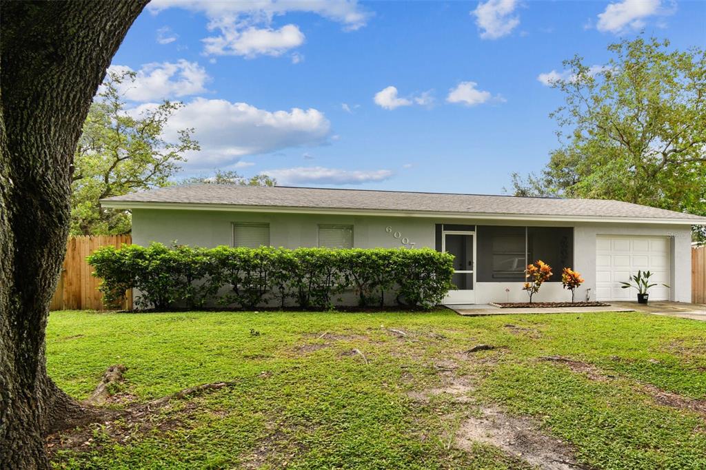 A single-story house with a light-colored exterior, a garage, and a large front yard — 6007 CALENDAR COURT W, LAKELAND, FL