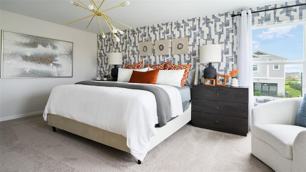 A bedroom features a patterned accent wall, a bed with orange pillows, and a chandelier — 36656 THORNHEDGE DRIVE, ZEPHYRHILLS, FL