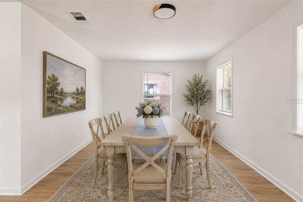 A dining room features a wooden table with six chairs, a rug, and wall art — 2312 SW FORT KING STREET, OCALA, FL