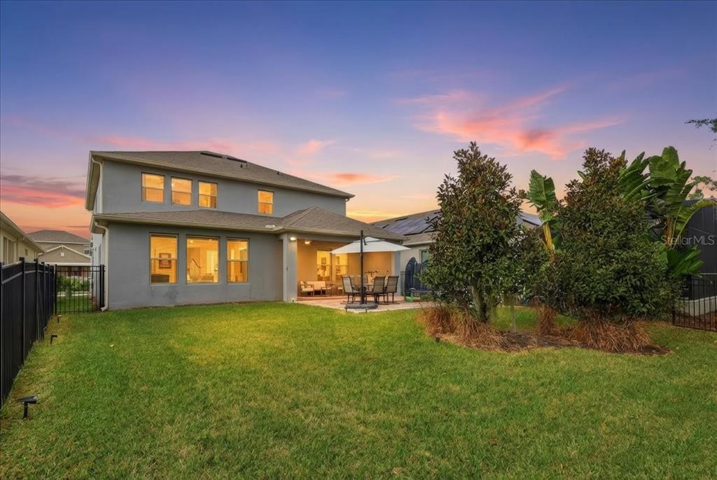 The exterior of a two-story house features a grassy backyard, patio, and landscaping — 9611 LOST CREEK DRIVE, WINTER GARDEN, FL