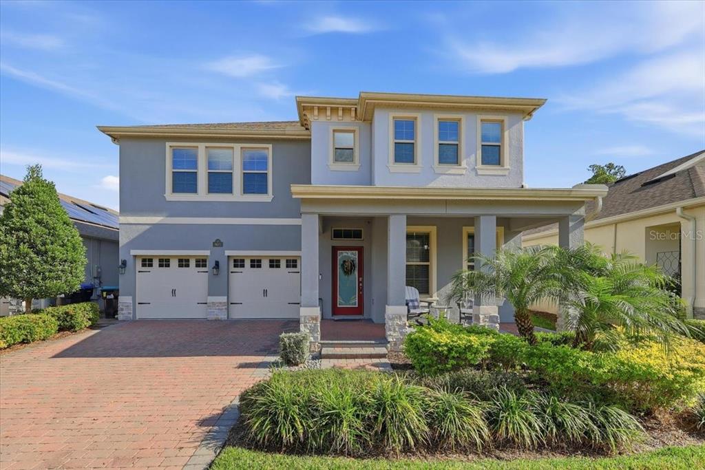 A two-story house with a gray exterior, a brick driveway, and a covered front porch — 9611 LOST CREEK DRIVE, WINTER GARDEN, FL