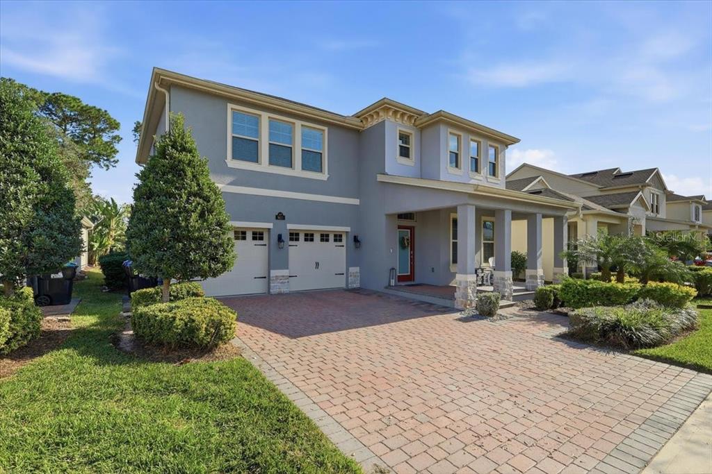 A two-story gray house with a brick paver driveway, two-car garage, and covered front porch — 9611 LOST CREEK DRIVE, WINTER GARDEN, FL