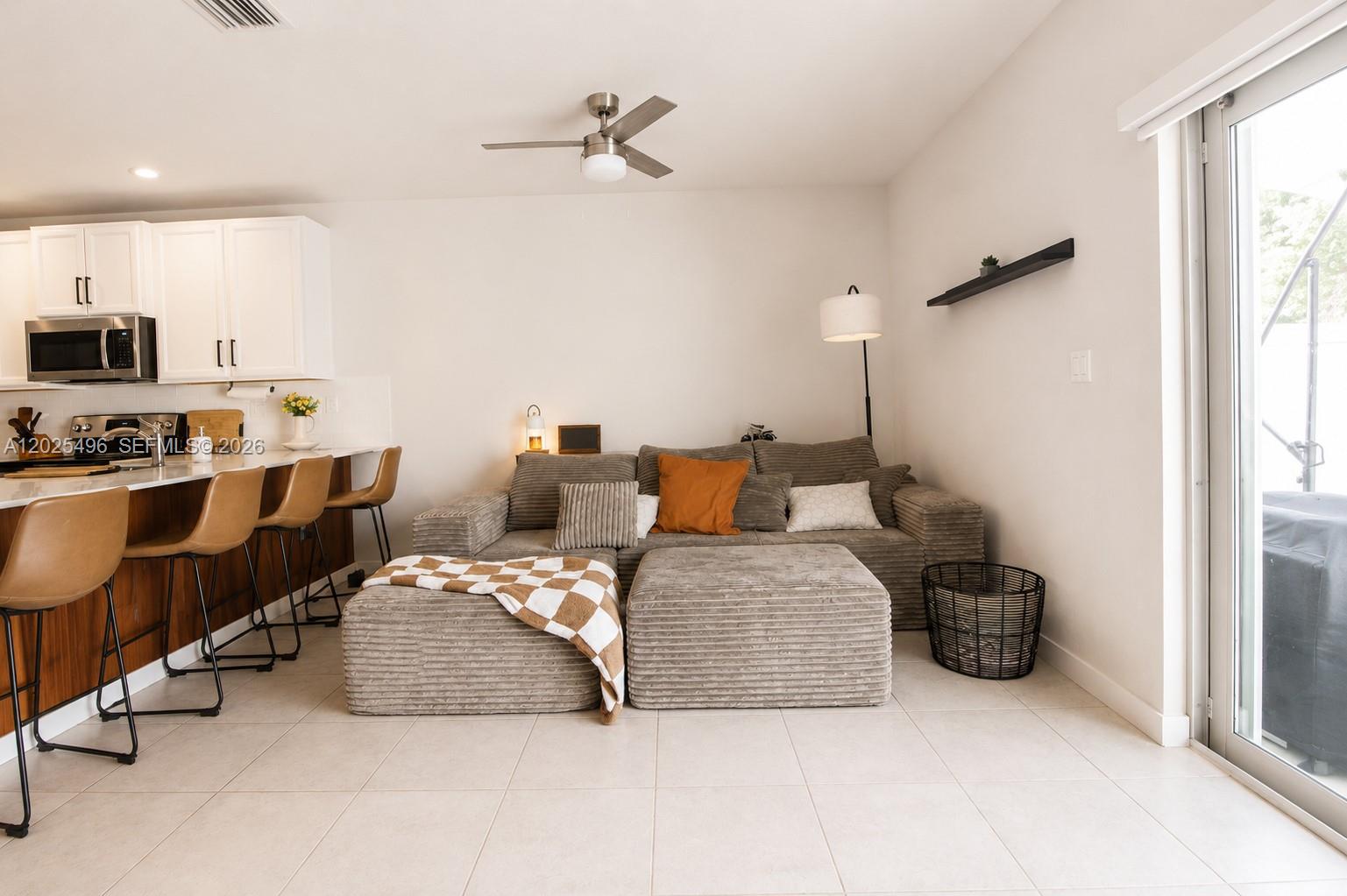 A living room with a corduroy sectional sofa, kitchen island, and bar stools — 1009 NW 4th Ter, Florida City FL 33034, FLORIDA CITY, FL