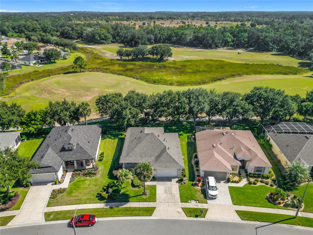 An aerial view shows suburban houses situated along a street next to a golf course — 3507 ARLINGTON RIDGE BOULEVARD, LEESBURG, FL
