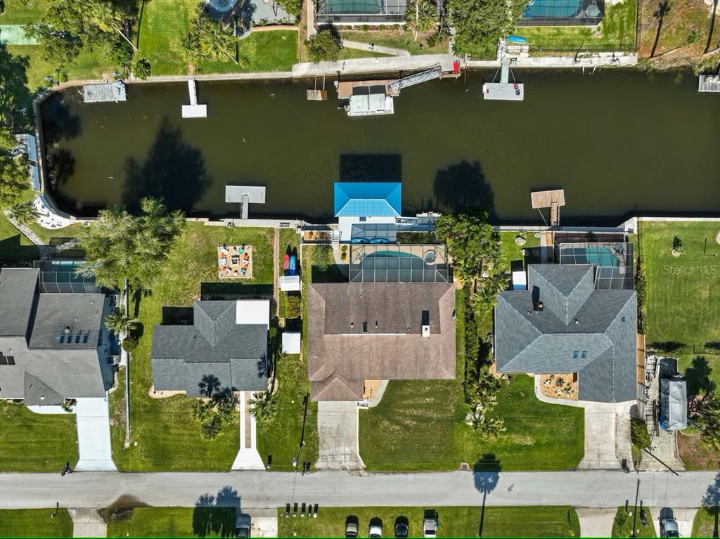 An aerial view shows three waterfront houses with pools and private docks along a canal — 3945 N TIMUCUA POINT, CRYSTAL RIVER, FL