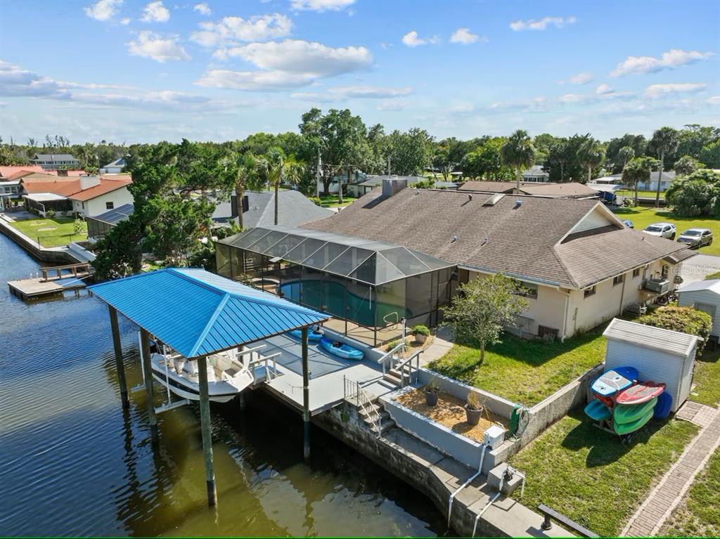 An aerial view of a waterfront house with a pool enclosure, boat dock, and kayaks — 3945 N TIMUCUA POINT, CRYSTAL RIVER, FL