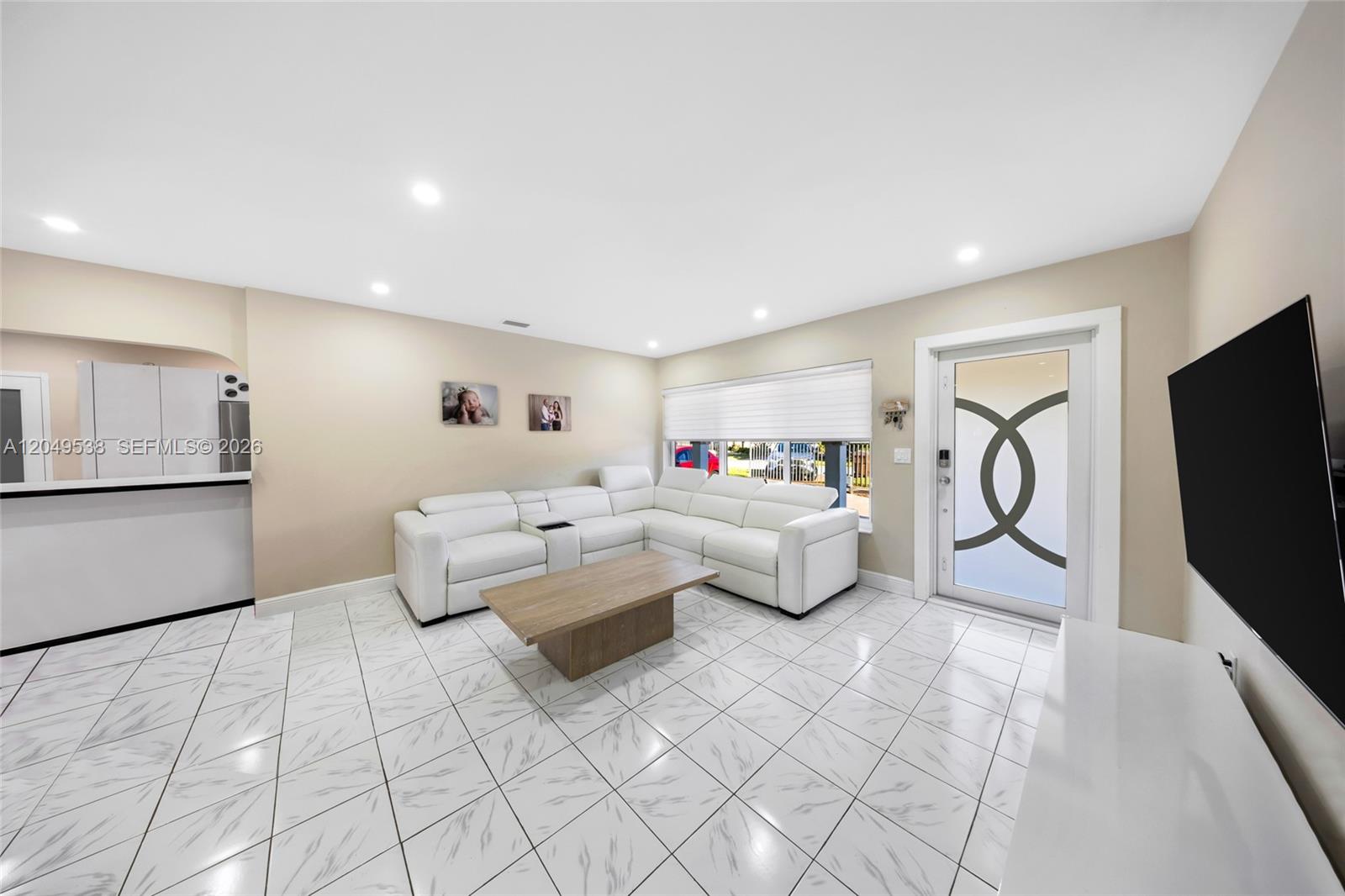 A living room features a white sectional sofa, a wooden coffee table, and tiled floors — 490 W 33rd Pl, Hialeah FL 33012, HIALEAH, FL
