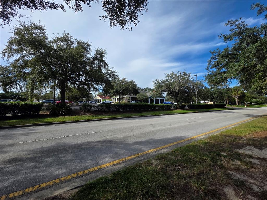 A view of a paved road leading toward a commercial building with a parking lot — TBD HIGHWAY 42, SUMMERFIELD, FL