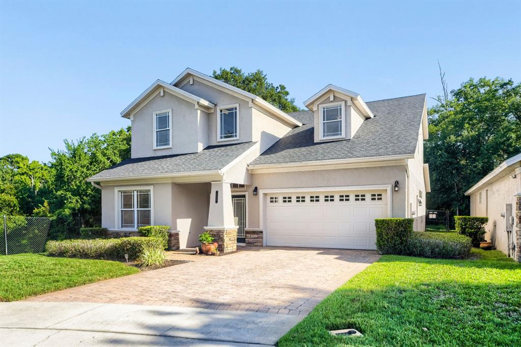 A two-story suburban house with a paved driveway, a two-car garage, and a front lawn — 122 SOPHIA MARIE CV, SANFORD, FL